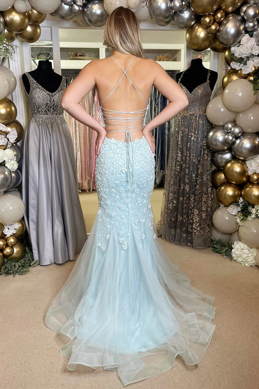 Vestido de fiesta con escote en V, apliques y cordones, con espalda abierta.